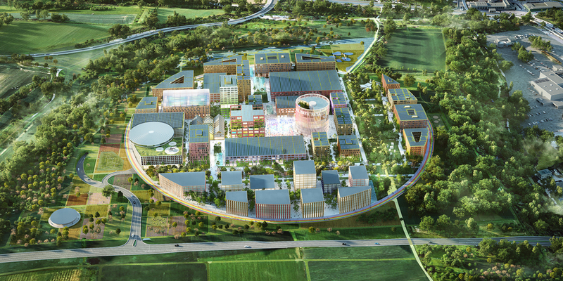 Luftbild-Rendering eines modernen, kreisförmig angelegten Campus mit zahlreichen Gebäuden, Wegen und Grünflächen, eingebettet in eine ländliche und bewaldete Umgebung. Über dem Bild befindet sich ein graues Banner mit den Logos und den Schriftzügen von Vodafone (links, rot) und IPAI (rechts, orange), getrennt durch ein „x“, das auf eine Partnerschaft hinweist.