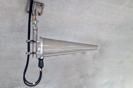 Eine neue Antennen-Technologie, speziell entwickelt für den Netzausbau in Tunneln, ist an einer grauen Wand montiert. Die Antenne hat eine konische Form und ist mit mehreren Kabeln verbunden, die ihre Funktion unterstützen. Diese Technologie zielt darauf ab, die Mobilfunkabdeckung in unterirdischen Bereichen zu verbessern und eine zuverlässige Signalübertragung zu gewährleisten.