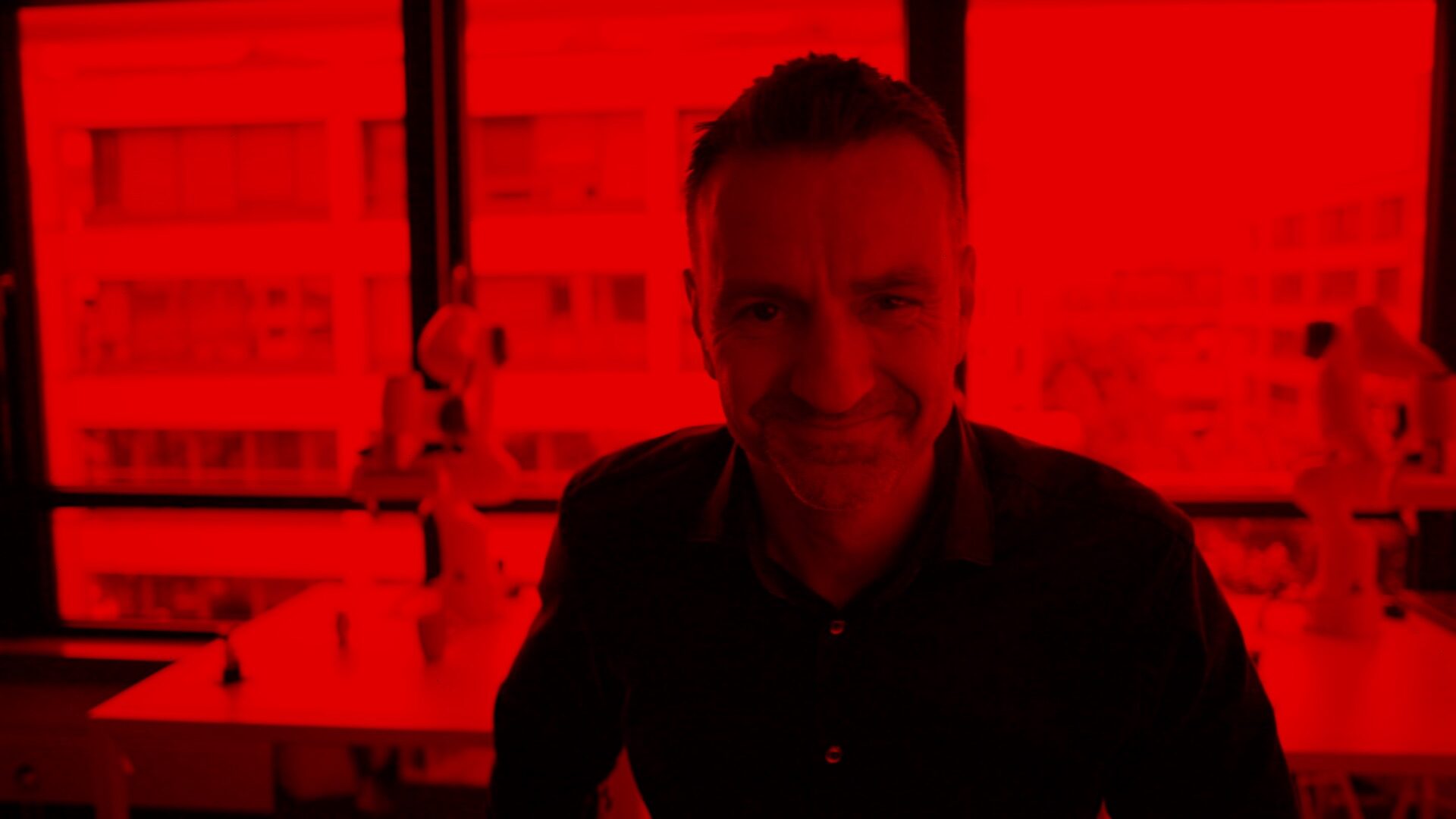 Vodafone Chef-Netzplaner Guido Weissbrich ist in einem Raum mit großen Fenstern im Hintergrund und schaut in die Kamera. Die gesamte Szene ist in rotes Licht getaucht.