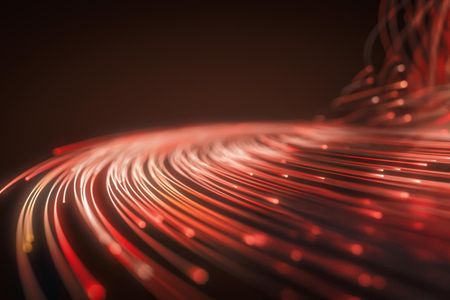 Das Bild zeigt eine Nahaufnahme von Glasfaserkabeln, die leuchtenden Rot strahlen. Die Kabel sind in Bündeln angeordnet und ihre Enden leuchten intensiv, was auf die Übertragung von Lichtsignalen hinweist. Der Hintergrund ist dunkel, wodurch die Farben der Glasfaserkabel besonders hervorgehoben werden. Diese Darstellung vermittelt den Eindruck von moderner Technologie und schneller Datenübertragung.